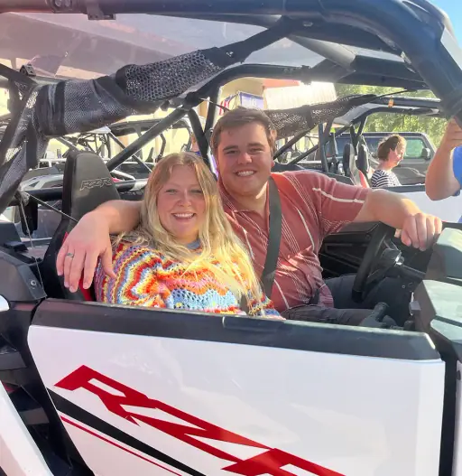 Happy couple smiling inside a Polaris RZR