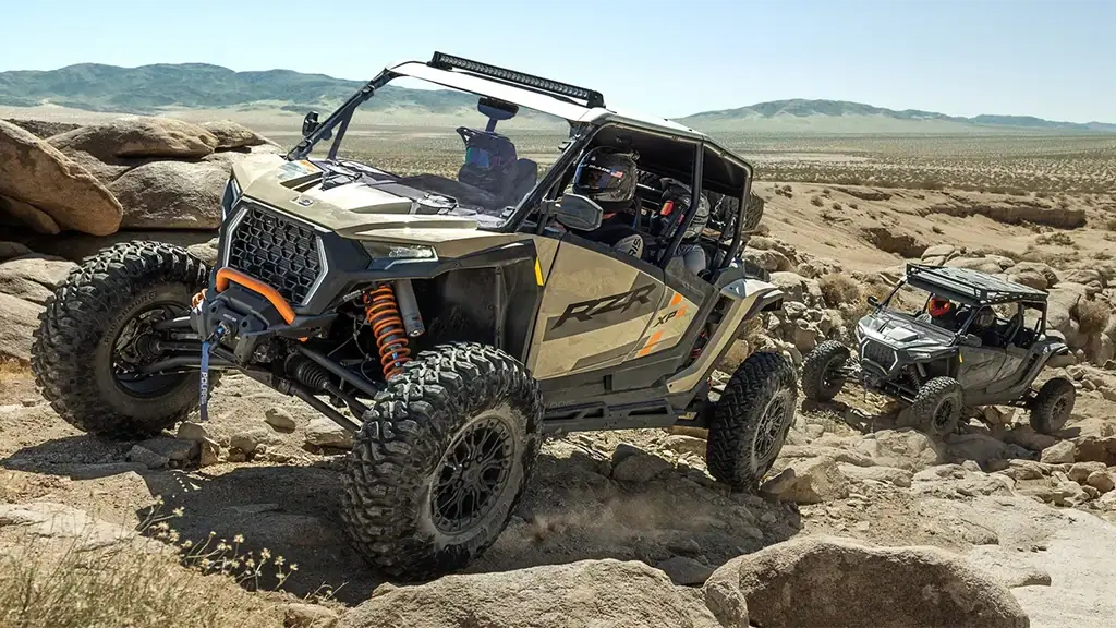 Polaris RZR climbing rocky terrain, available at Lake City Auto & Sports Center
