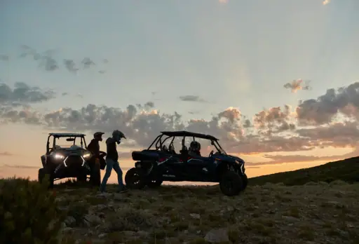 Two UTVs silhouetted against a Colorado sunset